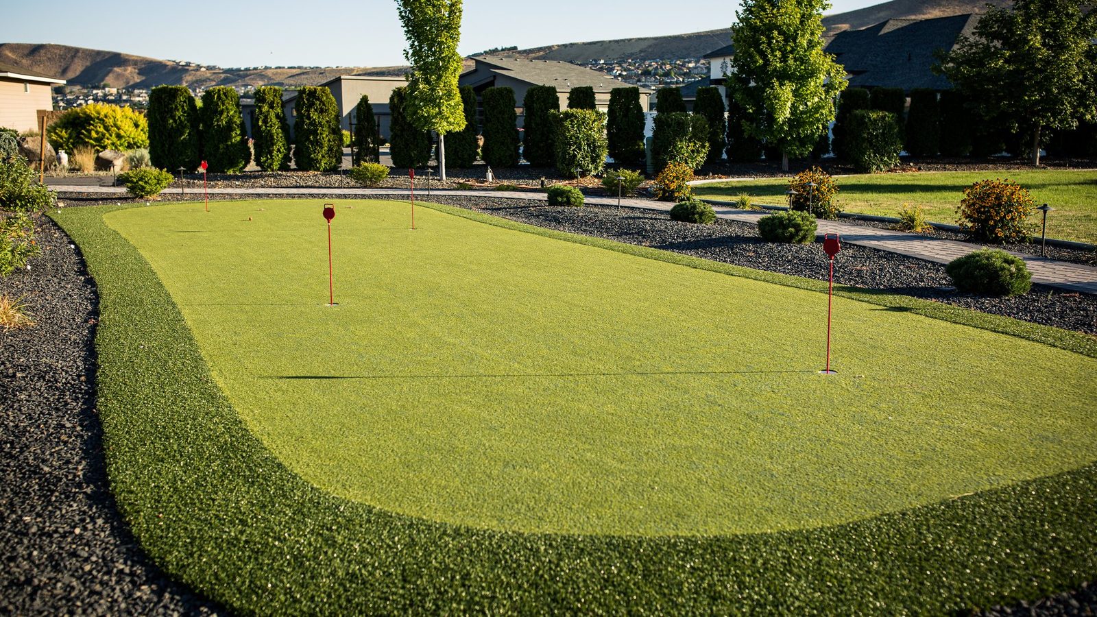 Multi-tier putting green with breaks and a sand bunker